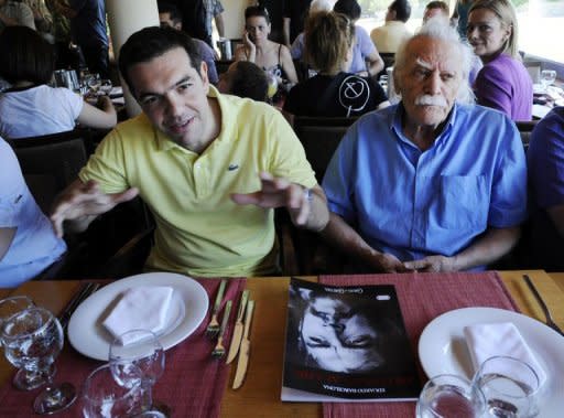 Syriza leftist radical party leader, Alexis Tsipras (L) and Greek resistance hero, politician and writer Manolis Glezos sit in a restaurant in Athens during a dinner with journalists