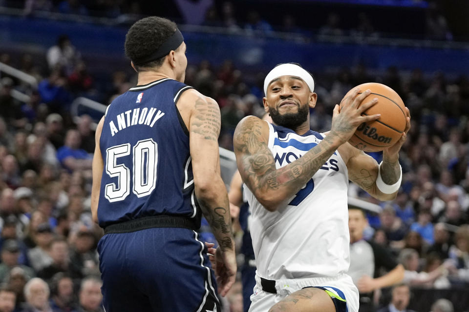 Minnesota Timberwolves guard Nickeil Alexander-Walker, right, moves to the basket against Orlando Magic guard Cole Anthony (50) during the first half of an NBA basketball game, Tuesday, Jan. 9, 2024, in Orlando, Fla. (AP Photo/John Raoux)