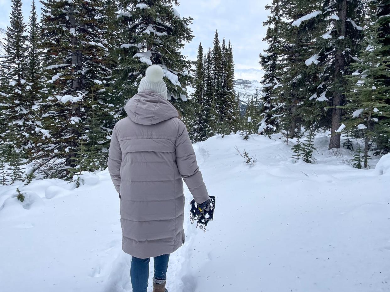 The author's friend holds a pair of microspikes, which we didn't end up using on our snow hike.