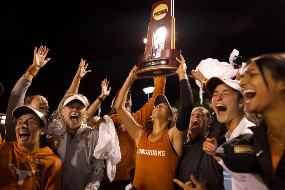 Texas women's tennis players hoist up the NCAA national championship trophy after defeating Oklahoma 4-1 in Sunday's championship match. The Longhorns finished their season 26-4.