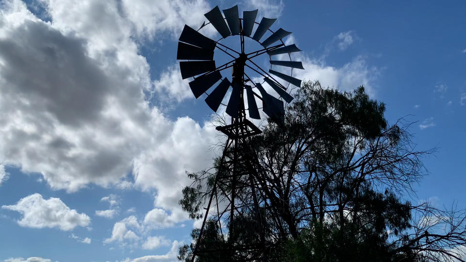 A windmill against a blue cloudy sky on the outskirts of the Pilliga.