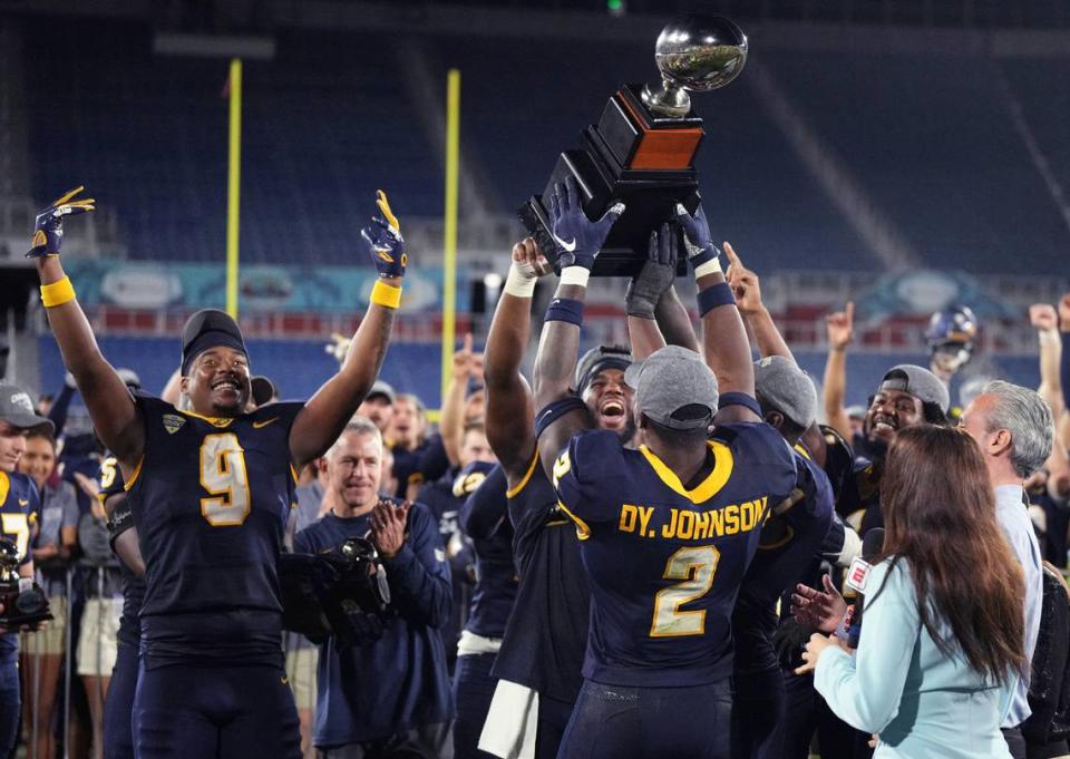 Toledo players hold up the trophy after a win over Liberty in the Boca Raton Bowl NCAA college football game Tuesday, Dec. 20, 2022, in Boca Raton, Fla.