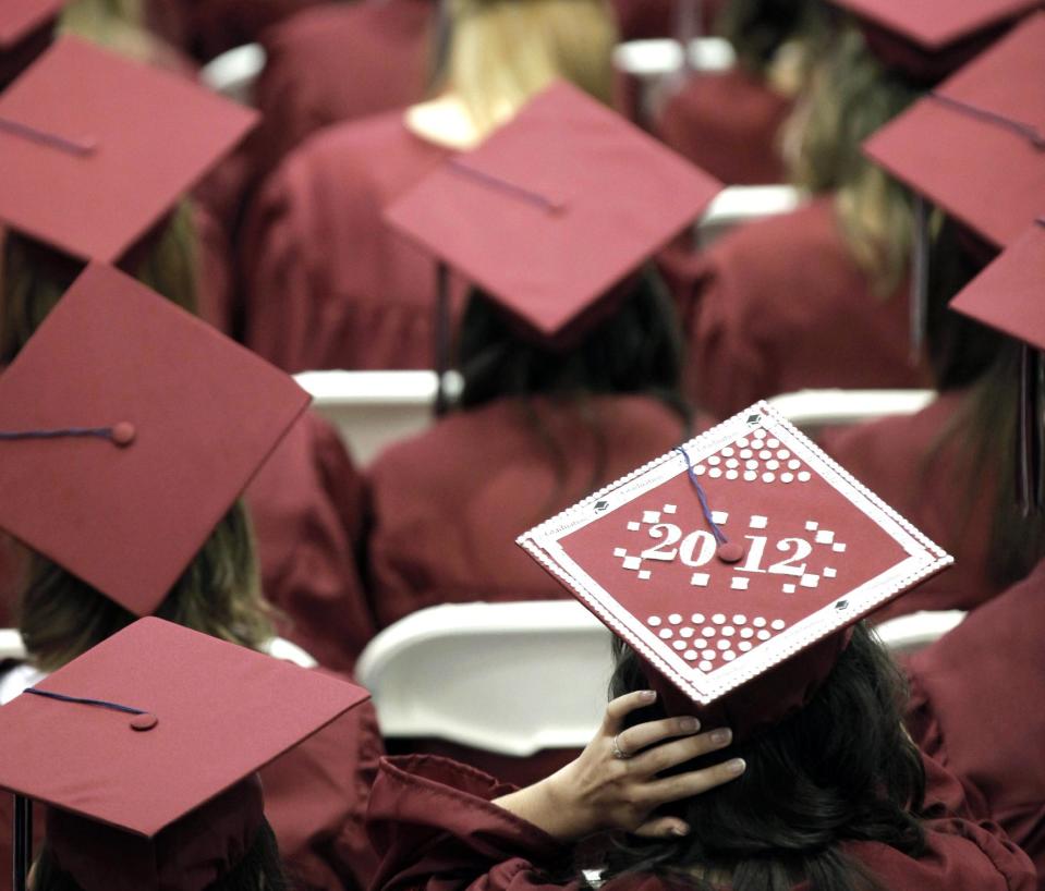 FILE - In this May 21, 2012, file photo, graduates from Joplin High School listen to speakers during commencement ceremonies in Joplin, Mo. U.S. public high schools have reached a milestone, an 80 percent graduation rate. Yet that still means 1 of every 5 students walks away without a diploma. Citing the progress, researchers are projecting a 90 percent national graduation rate by 2020. (AP Photo/Charlie Riedel, File)