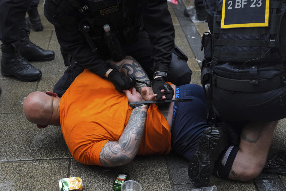 Police officers detain a soccer fan ahead of a semi final match between Netherlands and England at the Euro 2024 soccer tournament in Dortmund, Germany, Wednesday, July 10, 2024. (AP Photo/Markus Schreiber)