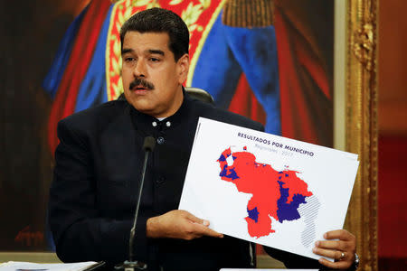 Venezuela's President Nicolas Maduro holds a map of Venezuela during a news conference at Miraflores Palace in Caracas, Venezuela October 17, 2017. REUTERS/Carlos Garcia Rawlins