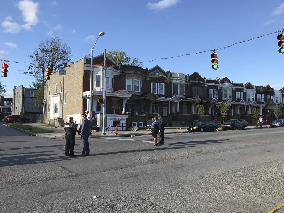 Authorities stand at Edmondson and Whitmore after multiple people were shot, Sunday, April 28, 2019, in Baltimore. (Kenneth K. Lam/The Baltimore Sun via AP)