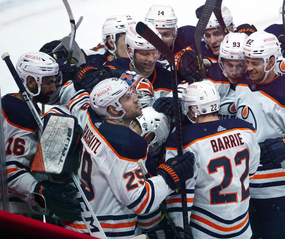 Edmonton Oilers' Dominik Kahun (21) is mobbed by teammates after scoring the winning goal against the Montreal Canadiens during overtime in an NHL hockey game, Wednesday, May 12, 2021 in Montreal. (Ryan Remiorz/Canadian Press via AP)