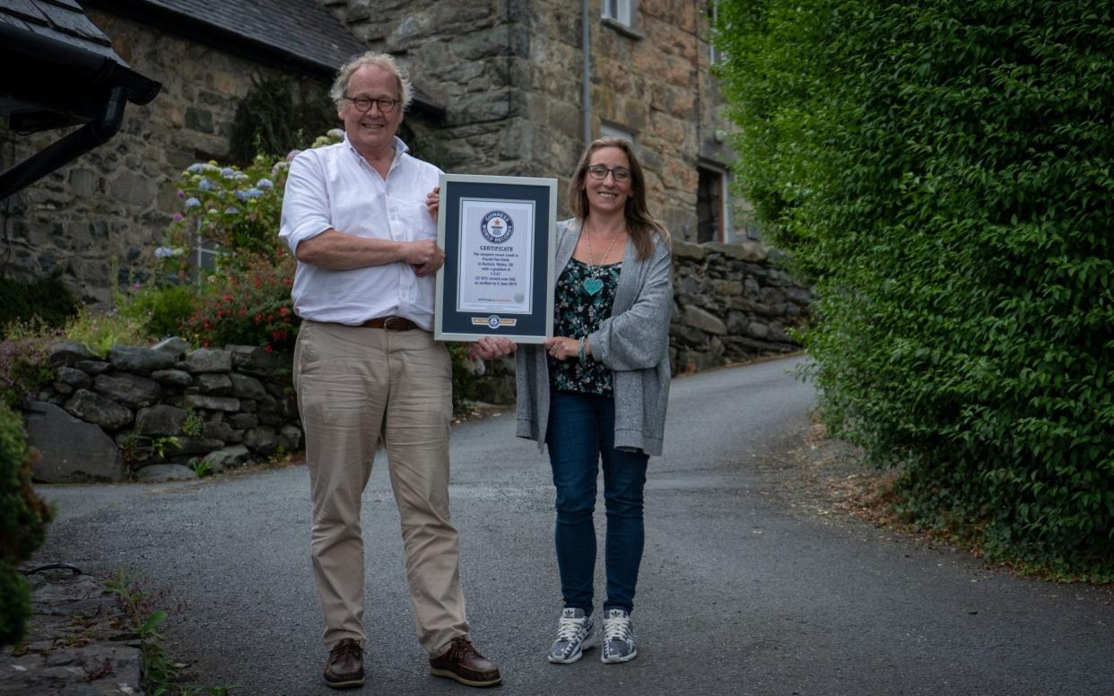 Gwyn Headley (left) and Sarah Badhan, stand on Ffordd Pen Llech, in the seaside town of Harlech, North Wales, with a certificate from Guinness World Records - PA