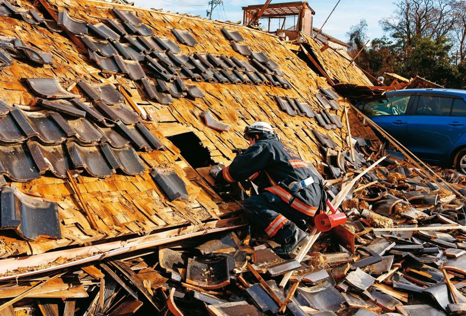 經歷大地震與隨後的海嘯，珠洲市滿目瘡痍，救災人員持手電筒沿屋搜索。