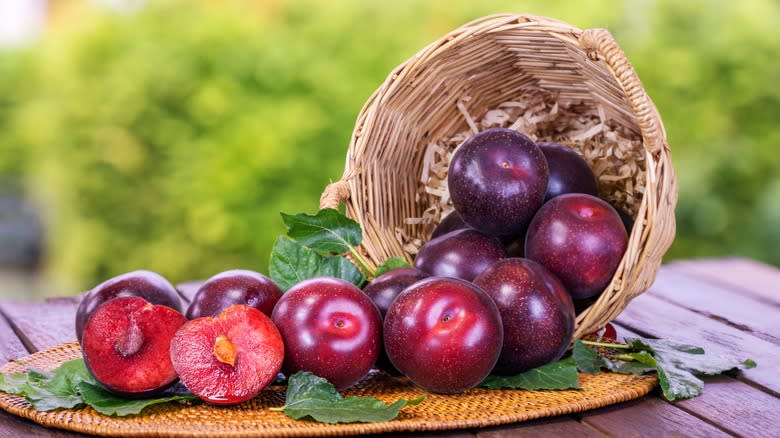 Plums spilling out of basket