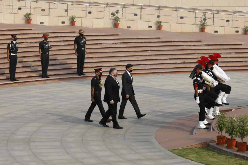 U.S. Secretary of State Mike Pompeo, foreground, and Secretary of Defence Mark Esper arrive to pay their tributes at the National War Memorial in New Delhi, India, Tuesday, Oct. 27, 2020. In talks on Tuesday with their Indian counterparts, Pompeo and Esper are to sign an agreement expanding military satellite information sharing and highlight strategic cooperation between Washington and New Delhi with an eye toward countering China. (Adnan Abidi/Pool via AP)