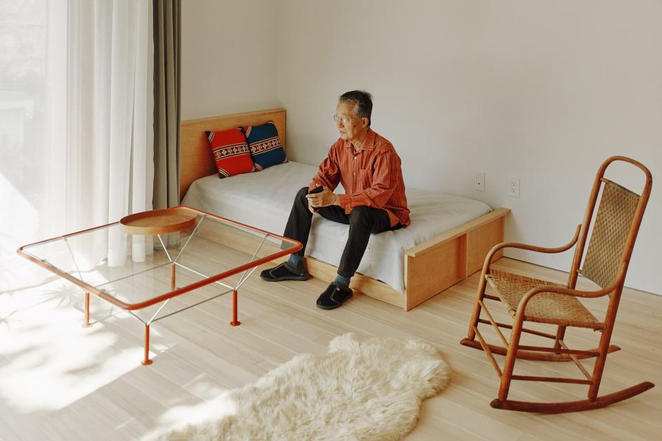 Architect Kyu Sung Woo sits on a twin bed he designed in the Cambridge, Massachusetts, home he shares with his wife, concert pianist Jung-Ja Kim.