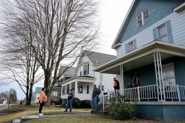 PHOTO: Neighbors gather outside a home as residents were allowed back in their homes after a derailment of a Norfolk Southern freight train in East Palestine, Pa, Feb. 9, 2023. (Gene J. Puskar/AP)