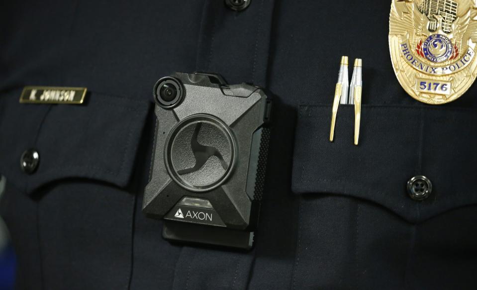 Phoenix Police Department Sgt. Kevin Johnson shows off the new Axon Body 2 body camera as another precinct gets their cameras assigned to them Wednesday, July 3, 2019, in Phoenix. Although body-worn cameras are becoming a police standard nationwide, Phoenix was among the last big departments to adopt their widespread use. (AP Photo/Ross D. Franklin)