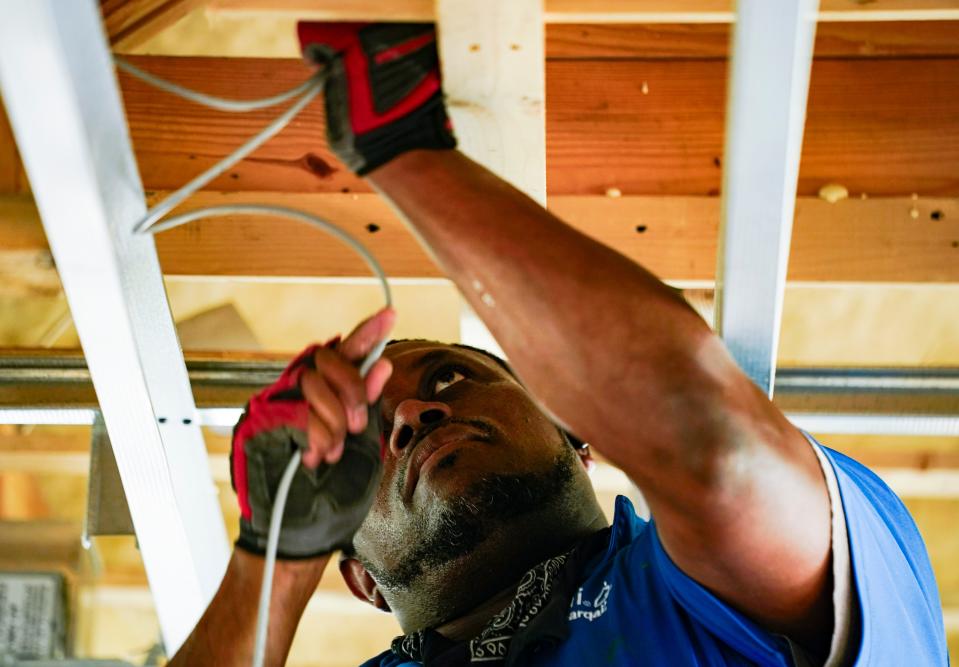 Carmelo Raphael works on wiring in a home at Bay Colony in Naples.