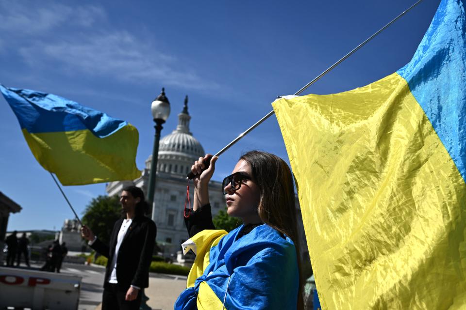 TOPSHOT - Activists wave Ukrainian flags outside the US Capitol in Washington, DC, on April 23, 2024. The US Senate is due to vote on the final foreign aid package of $95 billion in total military assistance to US allies, including money for Israel and Taiwan alongside the $61 billion earmarked for Ukraine -- is expected to land on President Joe Biden's desk for his approval by the end of the week. (Photo by Mandel NGAN / AFP) (Photo by MANDEL NGAN/AFP via Getty Images)