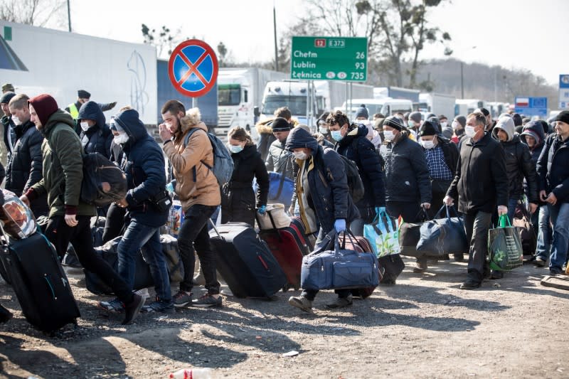 People queue to cross to Ukraine at the border crossing in Dorohusk