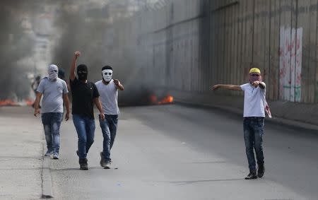 Palestinian protesters gesture during clashes with the Israeli troops in the West Bank town of Al-Ram, near Jerusalem October 22, 2015. REUTERS/Mohamad Torokman