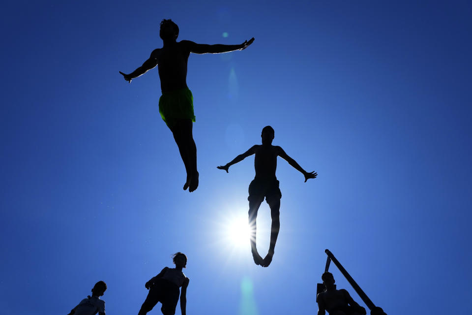 Young people jump into the water to cool down on a sweltering hot day at the Mediterranean Sea in Beirut, Lebanon, Sunday, July 23, 2023. (AP Photo/Bilal Hussein)