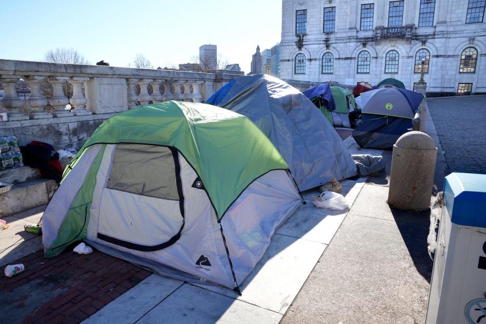 Tents remain on the terrace of the State House north entrance plaza Friday, two days after the encampment's residents were served eviction notices. A judge has put a stay on those notices pending a court hearing Wednesday.  THE PROVIDENCE JOURNAL/KRIS CRAIG