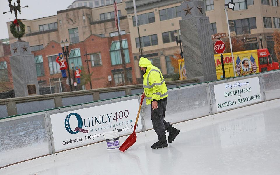 Quincy parks worker Larry Levasseur helps get the ice ready at the city's new seasonal rink.