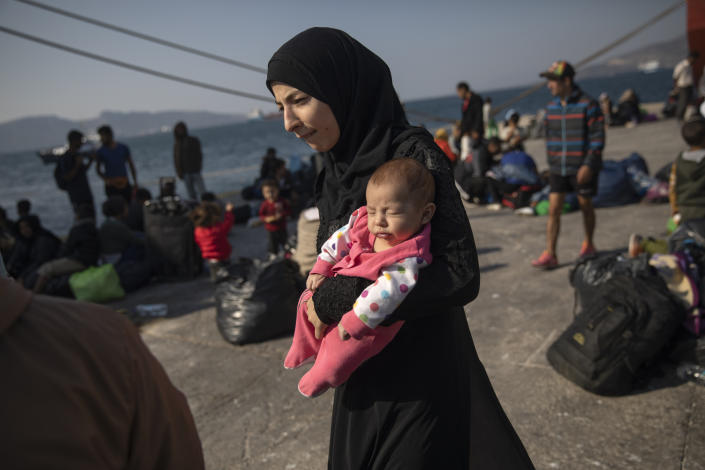 16 year-old Montaha from Aleppo, Syria, walks with her two-month-old daughter, Batour, after their arrival at the port of Elefsina, near Athens, on Tuesday, Oct. 22, 2019. About 700 refugees and migrants arrived from Samos island to the port of Elefsina as authorities have been moving hundreds of migrants deemed to be vulnerable from the overcrowded Samos camp to camps on the mainland. (Photo: Petros Giannakouris/AP)