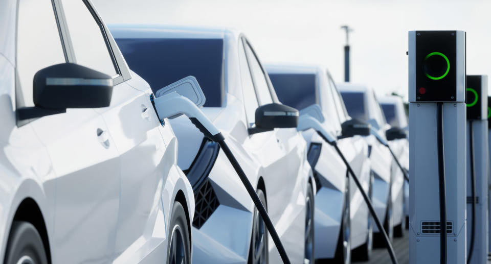 A row of electric cars parked next to chargers.