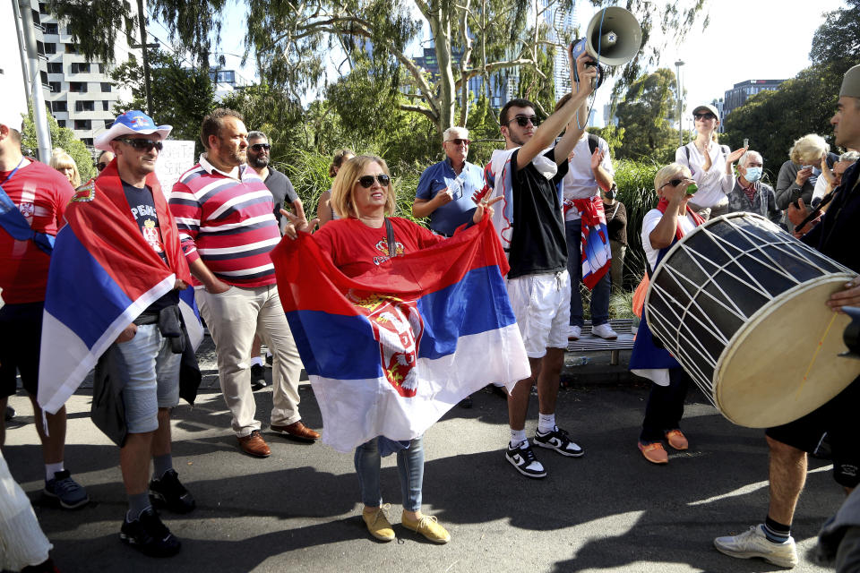 Protesters and fans of Serbia's Novak Djokovic gather outside the Park Hotel, used as an immigration detention hotel where Djokovic is confined in Melbourne, Australia, Saturday, Jan. 8, 2022. He has been confined to the detention hotel in Melbourne pending a court hearing on Monday, a week before the start of the Australian Open. Djokovic was barred from entering the country late Wednesday when federal border authorities at the Melbourne airport rejected his medical exemption to Australia's strict COVID-19 vaccination requirements. (AP Photo/Hamish Blair)