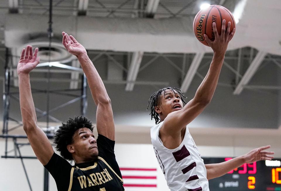 Lawrence Central Bears guard Da'John Craig (3) reaches for a lay-up against Warren Central's Jalen Hooks (4) on Tuesday, Feb. 28, 2023 at Warren Central High School in Indianapolis. Warren Central defeated the Lawrence Central Bears in overtime, 61-58.