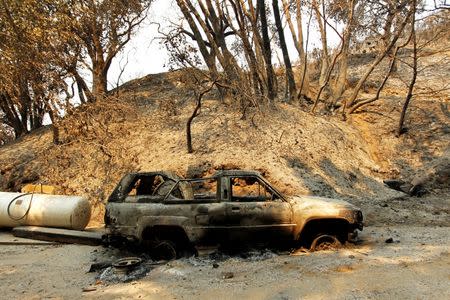 A destroyed vehicle sits on a property that was heavily damaged after the Soberanes Fire burned through the Palo Colorado area, north of Big Sur, California, U.S. July 31, 2016. REUTERS/Michael Fiala