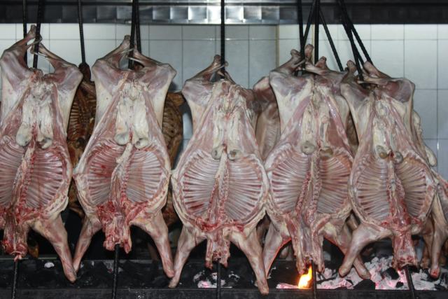 La Carne Del Jamón Del Cerdo Se Asa En Un Fuego Abierto En La