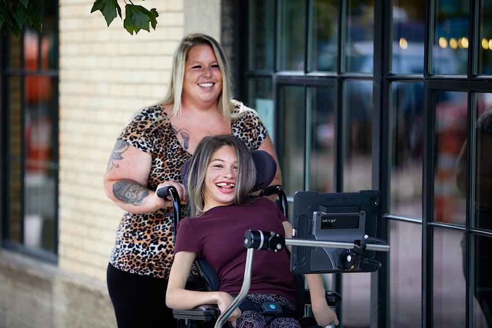 <p>A Tobii Dynavox's user and assistant with a TD Pilot attached to her wheelchair.</p>
