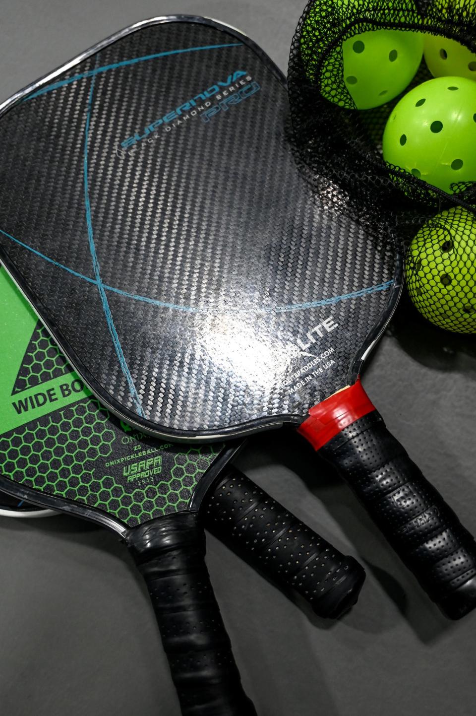 Pickleball paddles and ball used for playing with Gary Beaudoin's group on Friday, Jan. 27, 2023, at Court One Athletic Clubs in Lansing.