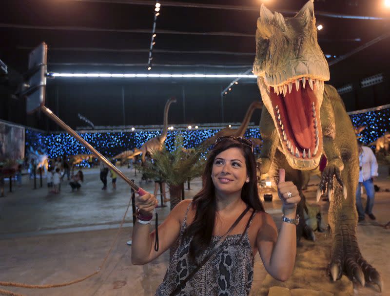 Foto de archivo de una mujer sacándose una selfie en una exhibición de dinosaurios en Beirut