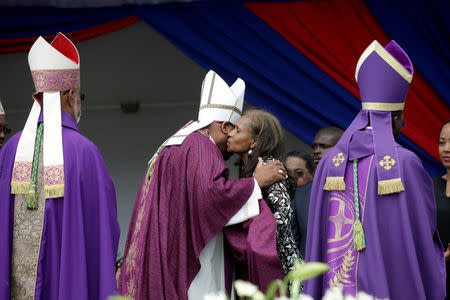 A priest who officiated the funeral of Haiti's former President Rene Preval embraces former First Lady Elisabeth D. Preval at the end of the religious ceremony in Port-au-Prince, Haiti, March 11, 2017. REUTERS/Andres Martinez Casares