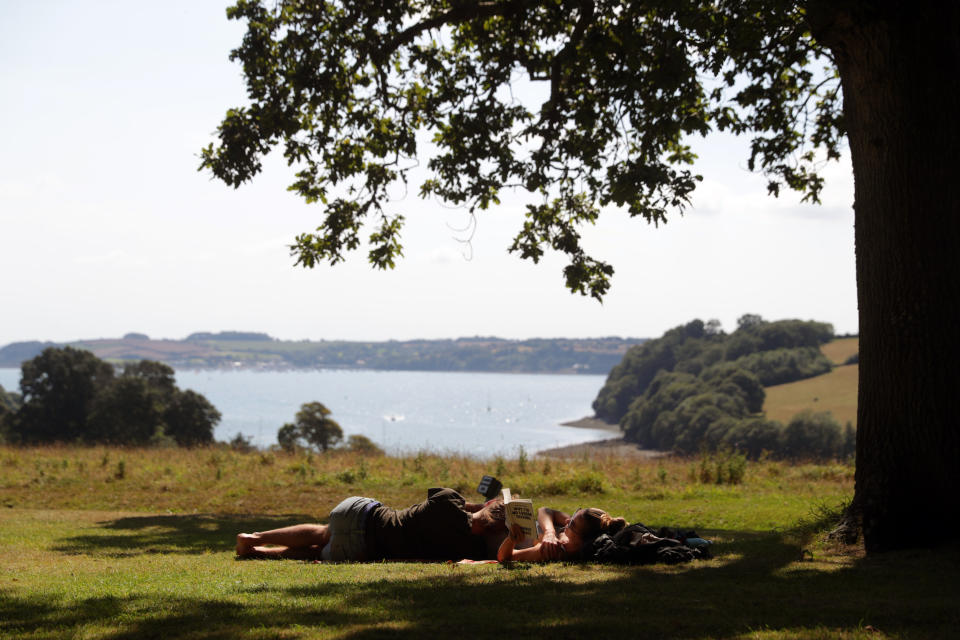 People find shade under a tree at the National Trust's, Trelissick Garden, in Cornwall, as the UK could see record-breaking temperatures with forecasters predicting Friday as the hottest day of the year.