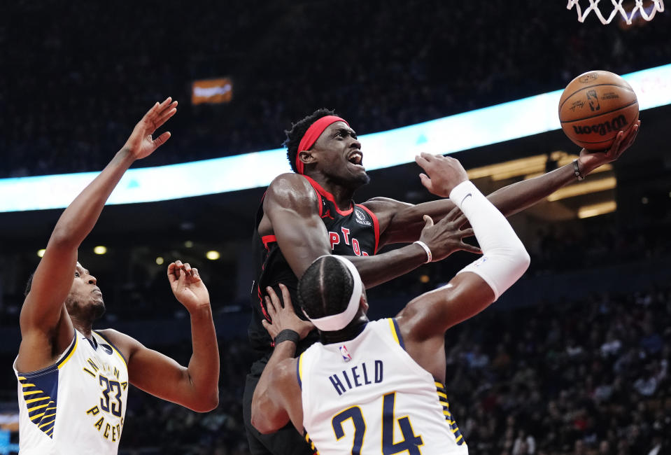 Toronto Raptors forward Pascal Siakam (43) shoots between Indiana Pacers center Myles Turner (33) and Pacers guard Buddy Hield (24) during the first half of an NBA basketball game in Toronto, Wednesday, March 22, 2023. (Frank Gunn/The Canadian Press via AP)