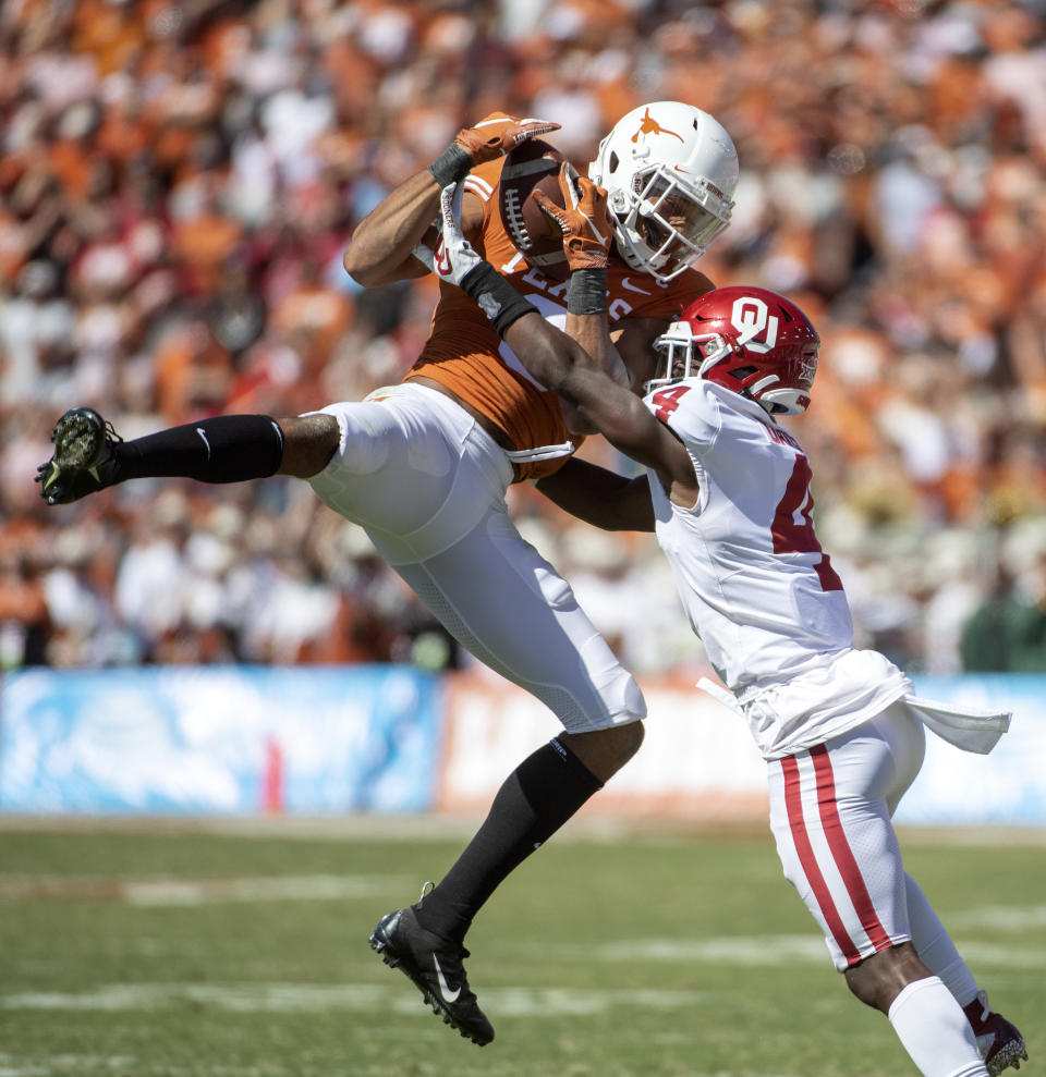 Texas wide receiver Collin Johnson makes a catch as Oklahoma cornerback Jaden Davis (4) defends in the second half of an NCAA college football game at the Cotton Bowl, Saturday, Oct. 12, 2019, in Dallas. Oklahoma won 34-27. (AP Photo/Jeffrey McWhorter)