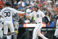 Detroit Tigers' Matt Vierling, right, is congratulated by Kerry Carpenter (30) after hitting a three-run home run, next to Kansas City Royals catcher Salvador Perez during the seventh inning of a baseball game, Saturday, April 27, 2024, in Detroit. (AP Photo/Jose Juarez)