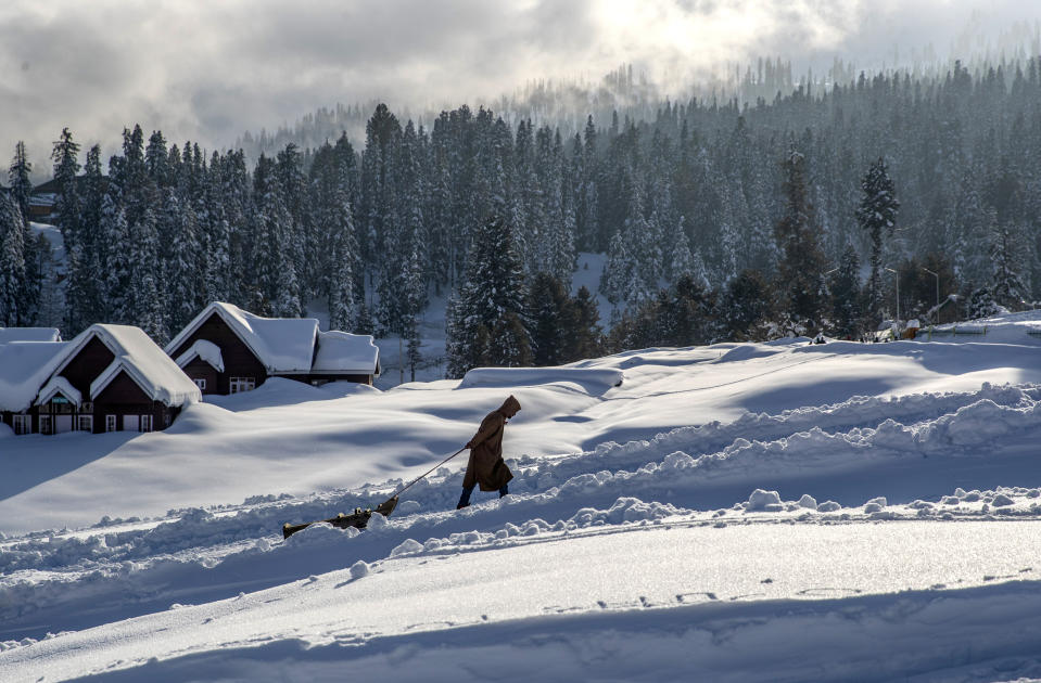 A Kashmiri sledge puller walks on a snow covered slope at Gulmarg, northwest of Srinagar, Indian controlled Kashmir, Saturday, Jan. 9, 2021. Snow this winter has brought along with it thousands of locals and tourists to Indian-controlled Kashmir's high plateau, pastoral Gulmarg, which translates as “meadow of flowers." (AP Photo/ Dar Yasin)