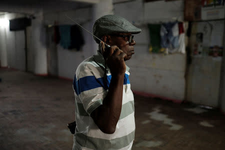 A resident of the abandoned Prestes Maia textile factory, which is occupied by a homeless movement, listens to a football game on his radio in a hallway, in downtown Sao Paulo, Brazil, May 13, 2018. REUTERS/Nacho Doce