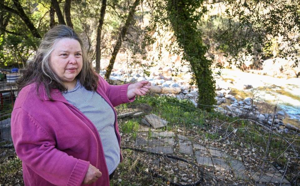 Terri Nishimura shows her view of the Merced River from her backyard while preparing to move out of the El Portal Trailer Park near Yosemite National Park on Sunday, March 13, 2022.