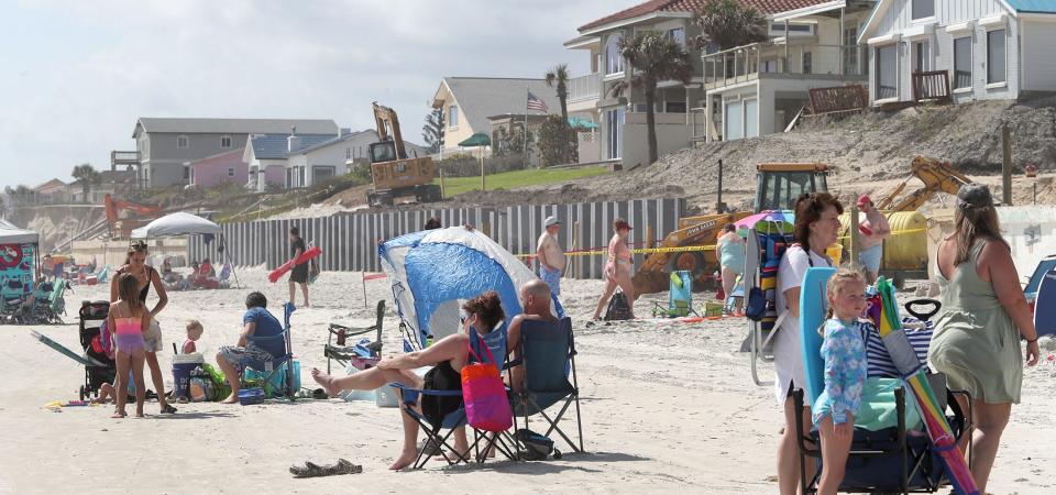 Beachgoers share the beach with equipment making seawall repairs in the 4200 block of South Atlantic Avenue, Friday April 7, 2023, in Wilbur-by-the-Sea.