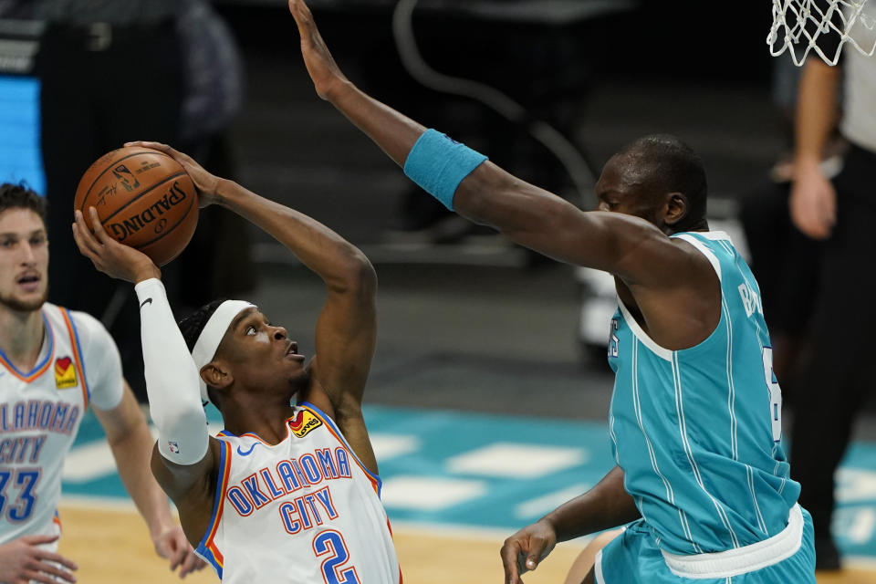 Oklahoma City Thunder guard Shai Gilgeous-Alexander shoots over Charlotte Hornets center Bismack Biyombo during the first half of an NBA basketball game in Charlotte, N.C., Saturday, Dec. 26, 2020. (AP Photo/Chris Carlson)