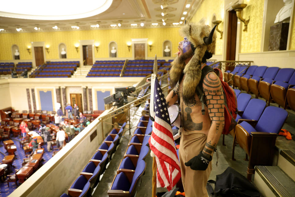 Jacob Chansley yells inside the Senate chamber.