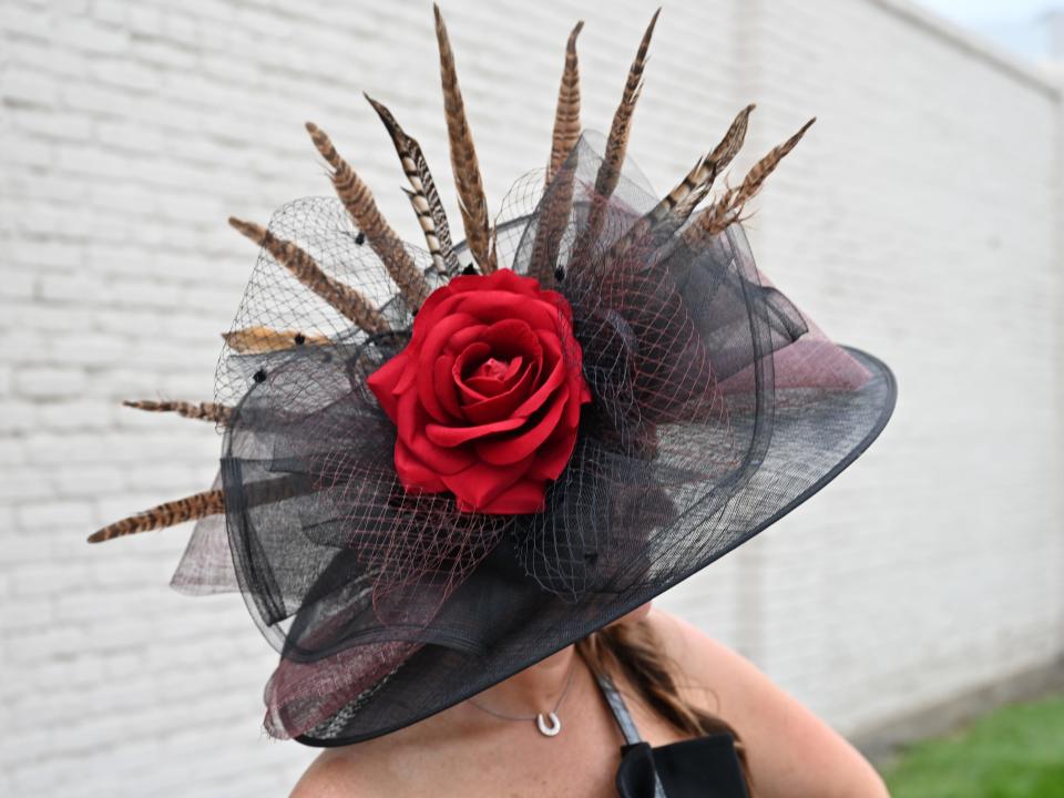 A black hat featuring feathers and a red rose at the 2023 Kentucky Derby.