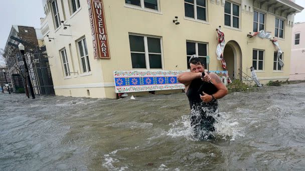 PHOTO: Trent Airhart wades through flood waters, Sept. 16, 2020, in downtown Pensacola, Fla. (Gerald Herbert/AP)