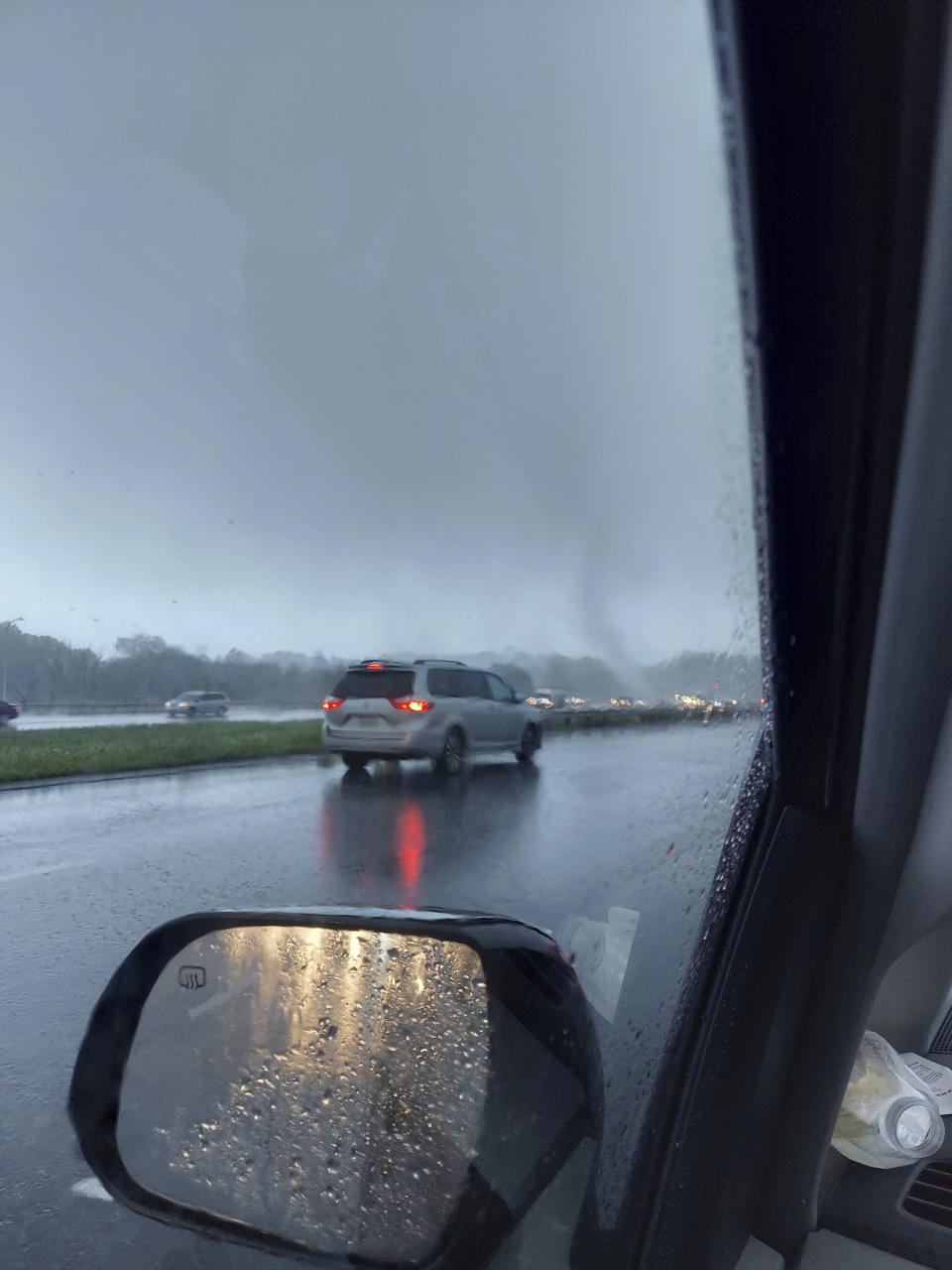 In this photo provided by George Viau, a tornado that firefighters say lifted a sedan 10 feet into the air is seen on I-295 in Johnston, R.I., on Friday, Aug. 18, 2023. Firefighters rushed to help the startled motorist on Interstate 295 on Friday and found her unharmed. Storms damaged homes and cars and made for hazardous driving across New England. (George Viau via AP)