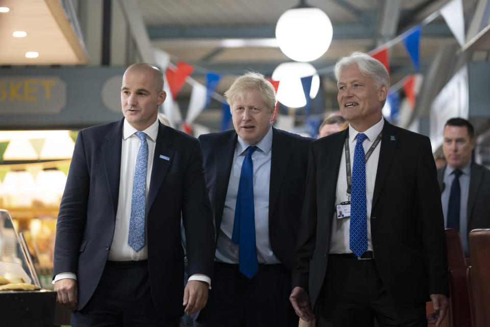 Britain's Prime Minister Boris Johnson, center, walks with Northern Powerhouse minister Jake Berry, left, and Damian Allen, Chief Executive Officer at Doncaster Council during a visit to Doncaster Market, in Doncaster, Northern England, Friday Sept. 13, 2019. Johnson will meet with European Commission president Jean-Claude Juncker for Brexit talks Monday in Luxembourg. The Brexit negotiations have produced few signs of progress as the Oct. 31 deadline for Britain’s departure from the European Union bloc nears. ( AP Photo/Jon Super)