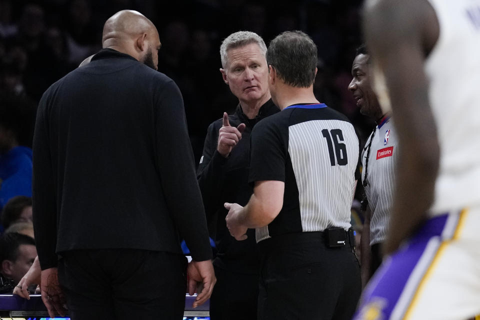 Los Angeles Lakers head coach Darvin Ham, left, and Golden State Warriors head coach Steve Kerr, center, talk with referee David Guthrie (16) after a shot clock malfunction during the second half of an NBA basketball game in Los Angeles, Saturday, March 16, 2024. (AP Photo/Ashley Landis)